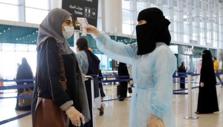 A security woman checks the temperature of a woman at King Khalid International Airport, after Saudi Arabia reopened domestic flights, following the outbreak of the coronavirus disease (COVID-19), in Riyadh, Saudi Arabia May 31, 2020. REUTERS/Ahmed Yosri